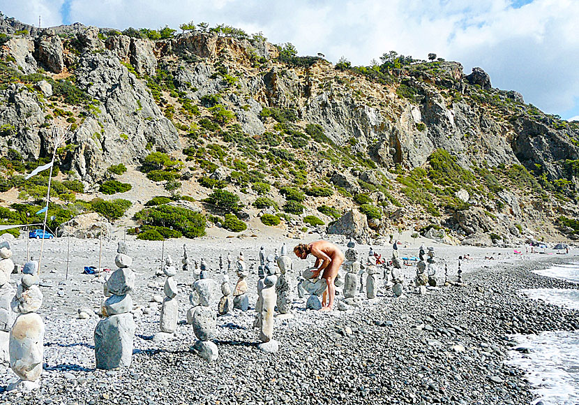 Naken stenbyggare vid den del av Sougia beach som är populär bland nudister.