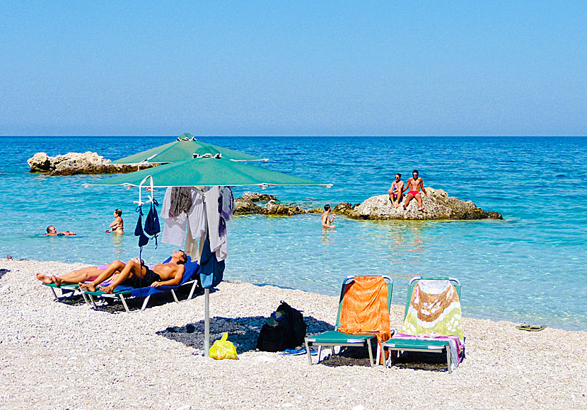 Solstolar och parasoll på Apella beach på Karpathos. 
