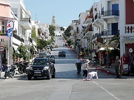 Kvinna på väg uppför krypgatan på Tinos.